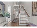 Spacious hallway with hardwood floors, staircase, arched doorways, and stylish decor at 2826 Walden Rd, Apex, NC 27502