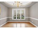 Dining room featuring hardwood floors, elegant chandelier, and a view of the neighborhood at 3312 Clandon Park Dr, Raleigh, NC 27613