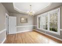 Bright dining room with hardwood floors, decorative chandelier, and large windows at 3312 Clandon Park Dr, Raleigh, NC 27613