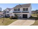 Charming two-story home featuring gray siding, a one-car garage, and a welcoming front porch with an American flag at 38 Winter Red Way, Benson, NC 27504