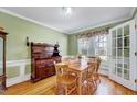 Inviting dining room with wood floors, a wooden table, and natural light from the windows at 408 Knolls View Dr, Fuquay Varina, NC 27526