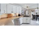 Spacious kitchen featuring granite countertops, white cabinets, and an open layout to the living area at 408 Knolls View Dr, Fuquay Varina, NC 27526