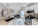 Well-lit kitchen with stainless steel appliances, granite countertops, and a view to the dining area at 408 Knolls View Dr, Fuquay Varina, NC 27526