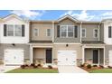 Exterior view of newly built townhomes, featuring neutral siding, and individual garages at 42 Sweet Meadow Rd, Angier, NC 27501