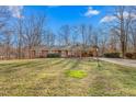 A well-maintained single story home featuring a paved driveway and large front lawn at 501 Orange High School Rd, Hillsborough, NC 27278