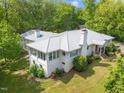 Aerial view of the home showcasing its updated metal roof, white brick, and lush landscaping at 513 N Nash St, Hillsborough, NC 27278