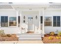 Close-up of the charming front porch with rocking chairs, decorative lights, and a welcoming entrance at 518 Parkview Dr, Burlington, NC 27215