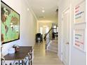 Bright entryway featuring a staircase and light colored flooring with a view into the living room at 519 Flat Ford Rd, Hillsborough, NC 27278