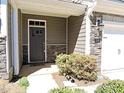 Exterior view of a townhome's front door, featuring stone accents and landscaping at 519 Flat Ford Rd, Hillsborough, NC 27278
