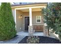 Inviting covered porch with stone pillars, a bench, and well-maintained landscaping at 5204 Sapphire Springs Dr, Knightdale, NC 27545