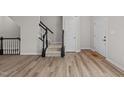 Bright foyer with beautiful wood flooring and staircase with black and white banister at 5421 Vista View Ct, Raleigh, NC 27612