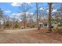 Charming single-story home featuring a welcoming porch and large front yard with mature trees and ample space for parking at 5505 Farrington Rd, Chapel Hill, NC 27517