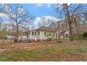 Cozy single-story home with a brick chimney and a charming porch, surrounded by mature trees in a serene setting at 5505 Farrington Rd, Chapel Hill, NC 27517