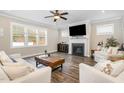 Bright living room with fireplace, ceiling fan, hardwood floors, and large windows at 562 Boulder Point Dr, Chapel Hill, NC 27516