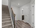 Inviting entryway features hardwood floors, staircase, and access to a half-bathroom with modern fixtures at 6351 Perry Creek Rd, Raleigh, NC 27616