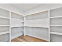 Spacious walk-in closet with custom shelving and ample storage, and wood-look floors at 680 Jasmine Rd, Fuquay Varina, NC 27526