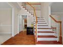 Inviting foyer features gleaming hardwood floors and a staircase with wooden railings at 7 Starwood Ln, Durham, NC 27712