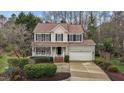 Inviting two-story home with a cozy front porch, well-maintained landscaping, and an attached two-car garage at 733 Hillsford Ln, Apex, NC 27502