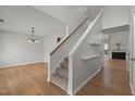 Bright foyer with hardwood floors, staircase, and views into the living room and dining room with fireplace at 733 Hillsford Ln, Apex, NC 27502