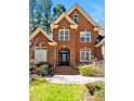 Close-up of brick home's elegant arched entry and manicured landscaping at 81517 Alexander, Chapel Hill, NC 27517