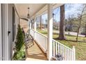 Inviting front porch with white railing and cozy seating, perfect for relaxing at 817 Roanoke Dr, Cary, NC 27513