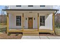 Inviting front porch with wood columns, craftsman style door, and stylish lighting enhancing curb appeal at 1019 Thompson Rd, Four Oaks, NC 27524