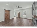 Open living area with wood-look floors, recessed lighting, barn door, and lots of natural light at 1019 Thompson Rd, Four Oaks, NC 27524