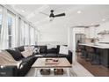 Open-concept living space featuring a comfortable sectional, ceiling fan, and a view into the modern kitchen at 10320 Sablewood Dr # 107, Raleigh, NC 27617