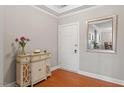 Welcoming entryway features stylish console table, fresh flowers, and attractive mirror, complemented by warm hardwood floors at 10511 Rosegate Ct # 203, Raleigh, NC 27617
