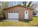 Detached single-car garage with a white door, side entry and concrete driveway, surrounded by green lawn at 107 Rencher St, Hillsborough, NC 27278