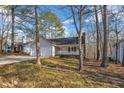 Picture of a one story home with a two-car garage and a quaint front porch, nestled among the trees at 1107 Goldendale Dr, Durham, NC 27703
