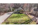 Aerial view of a quaint home with a fenced front yard and mature trees providing shade and privacy at 113 Pony Dr, Louisburg, NC 27549