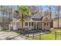 Inviting home with a fenced yard, charming porch, and unique two-level entry, accented by a mature palm tree at 113 Pony Dr, Louisburg, NC 27549