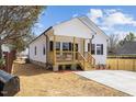 Inviting home exterior featuring a covered porch with seating and fresh landscaping at 1335 Elrado St, Burlington, NC 27217