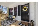 Close-up of the front porch, showing seating, a welcome mat, and a decorative wreath on the front door at 1335 Elrado St, Burlington, NC 27217