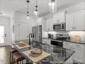 The kitchen features white cabinets, black granite countertops, and stainless steel appliances at 141 N District Ave # 295, Clayton, NC 27527