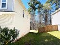 A small patch of the sideyard next to the house and a wooden fence at 204 Hillview Dr, Durham, NC 27703