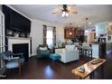 Open-concept living room with a fireplace, modern furnishings, and hardwood floors at 2144 Waterview Dr, Graham, NC 27253