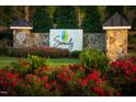 Stone pillars with the community name 'Serenity' adorn the entry with colorful flowers and manicured shrubbery at 217 Inspiration Way Way, Fuquay Varina, NC 27526
