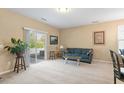 Bright living room featuring neutral carpet, sliding doors, and a cozy seating area with plenty of natural light at 2306 Stoney Spring Dr, Raleigh, NC 27610
