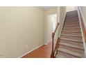 Inviting staircase with carpeted steps and a classic wooden banister, leading to the upper level of the home at 2306 Stoney Spring Dr, Raleigh, NC 27610