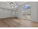 Living room featuring hardwood floors, high ceilings, ample natural light, and a ceiling fan at 2613 Coxindale Dr, Raleigh, NC 27615