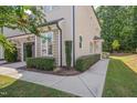 Corner view of the townhome featuring manicured landscaping, covered entry, and sidewalk at 300 Mariah Towns Way, Garner, NC 27529