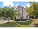 View of the townhome featuring established landscaping, a two-car garage, and classic siding at 300 Mariah Towns Way, Garner, NC 27529