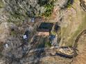 Scenic bird's eye view of a home surrounded by lush greenery and a flowing creek at 3010 University Station Rd, Durham, NC 27705