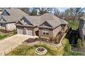 Elevated view of a brick home with manicured lawn and stone-lined garden at 310 Macallan, Burlington, NC 27215