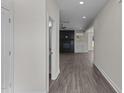 Hallway leading to a cozy living space with a fireplace, hardwood floors, and neutral paint at 316 Little Lady Trail, Zebulon, NC 27597