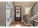 Elegant foyer with hardwood floors, a staircase with iron railing, and a stylish front door at 3421 Griffice Mill Rd, Raleigh, NC 27610