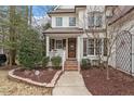 Inviting front porch with brick steps and a well-manicured landscape featuring mature trees and shrubbery at 3421 Griffice Mill Rd, Raleigh, NC 27610