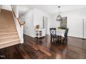 Bright dining room with hardwood floors, modern light fixture, and staircase at 4443 Crystal Breeze St, Raleigh, NC 27614